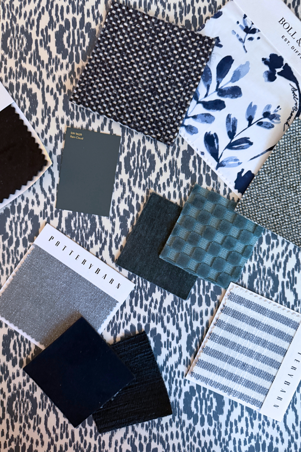 Collection of fabric swatches in various patterns and colors on a textured surface.